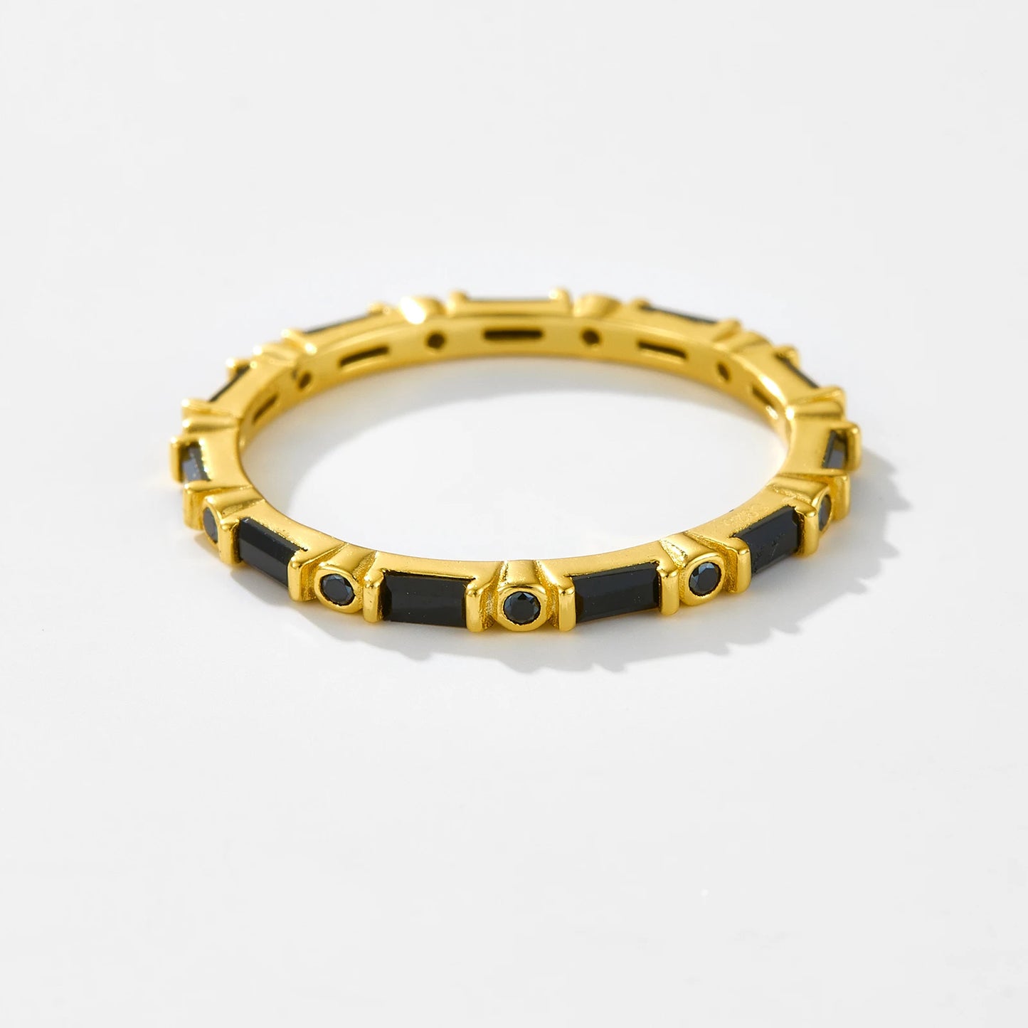 Gold ring with alternating black baguette and round stones in eternity style