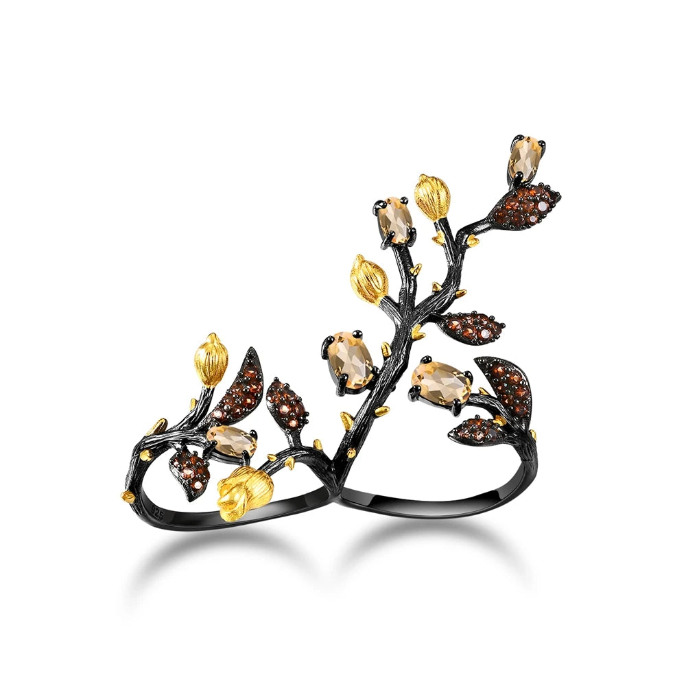 Double-finger black ring shaped like a flowering branch with purple, green, and gold detailing