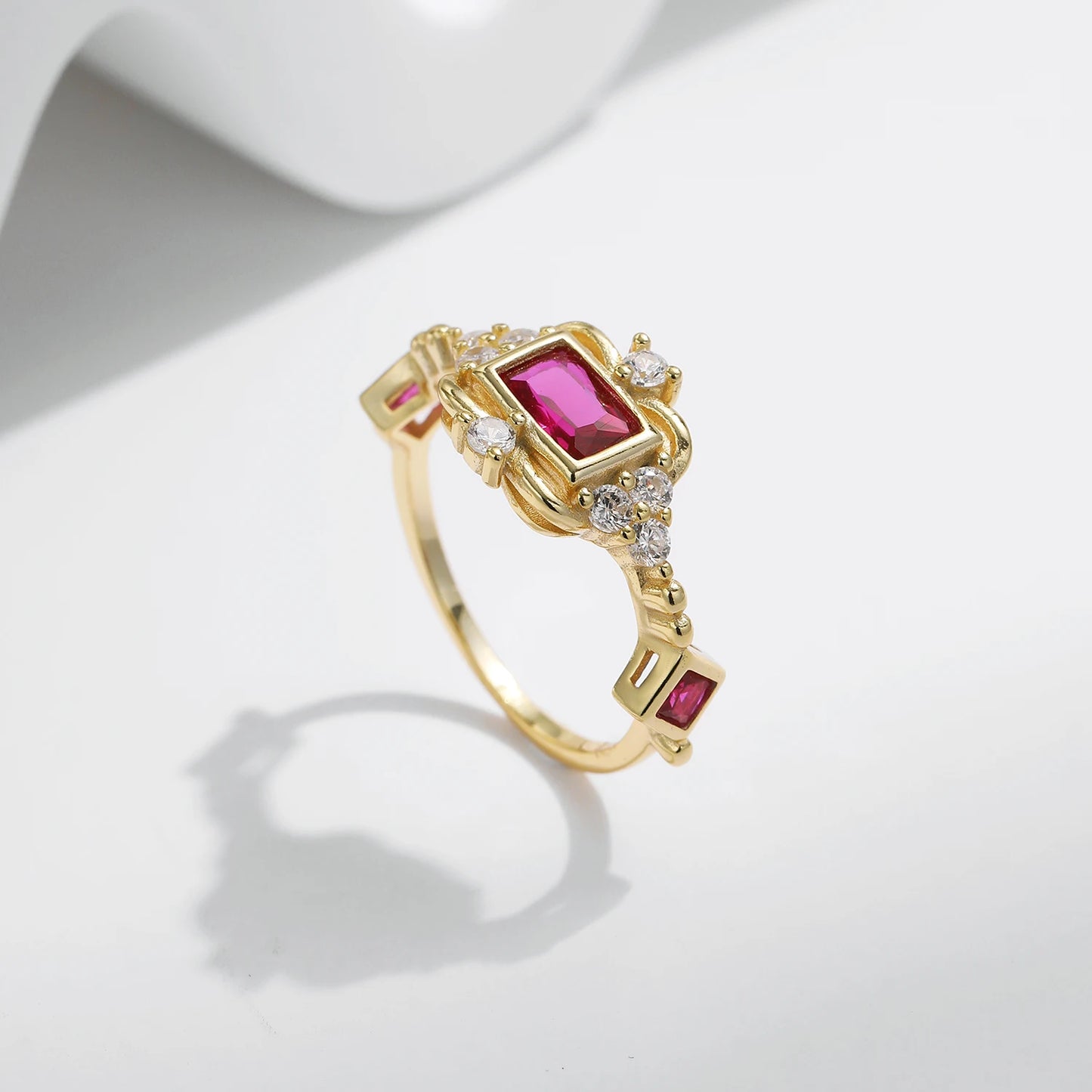 Gold-plated ring with rectangular ruby-red stone and vintage-inspired clear accents