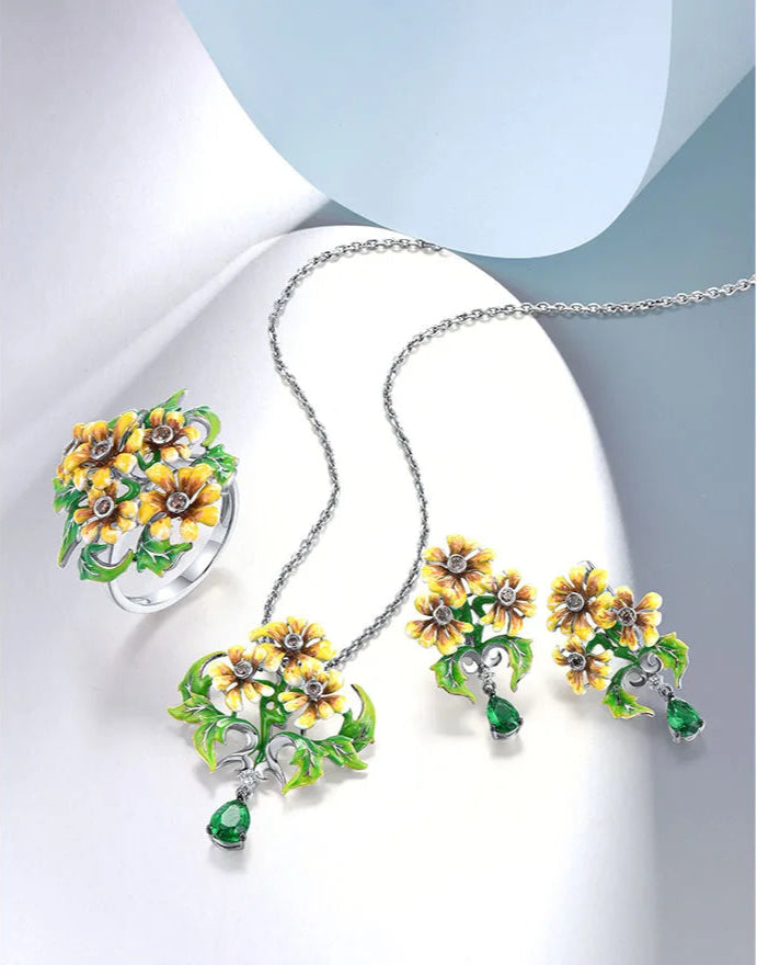 Jewelry set featuring yellow-orange flowers with green enamel leaves and teardrop green gemstone dangles