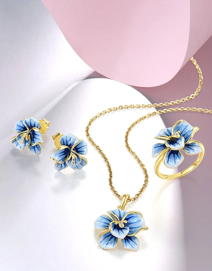 Jewelry set with hand-painted blue flower designs in gold-tone metal, featuring crystal accents