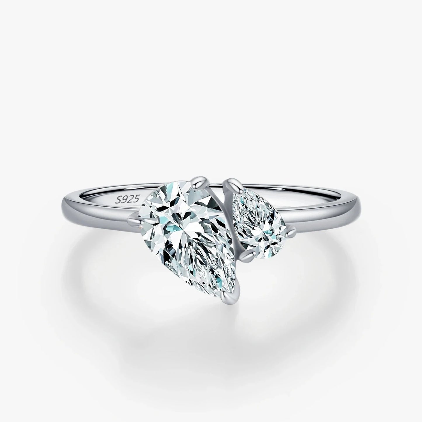 Silver ring with two pear-cut white gemstones facing opposite directions, set in a minimalist open band design.