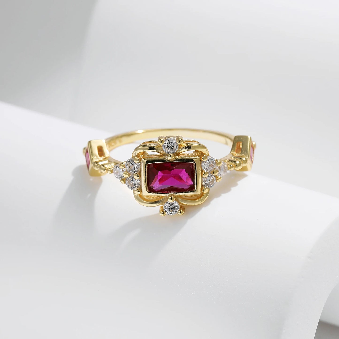 Gold-plated ring with rectangular ruby-red stone and vintage-inspired clear accents