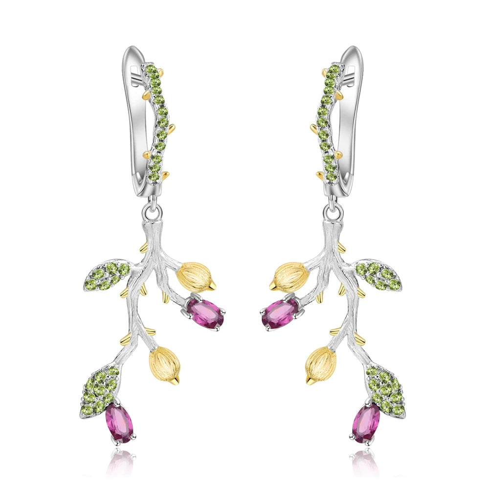 Silver branch-inspired earrings with green leaves and purple gemstone drops
