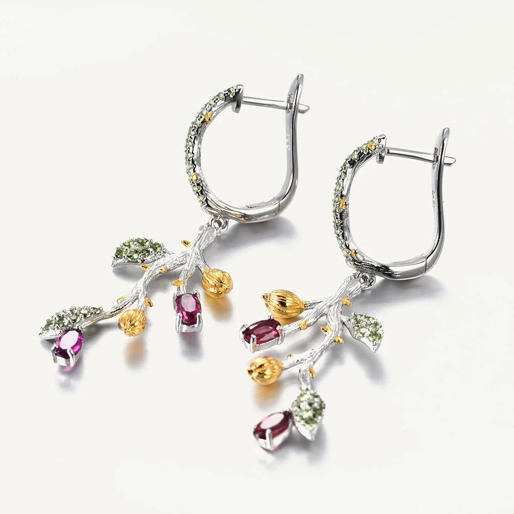 Botanical-inspired earrings with purple, green, and gold accents