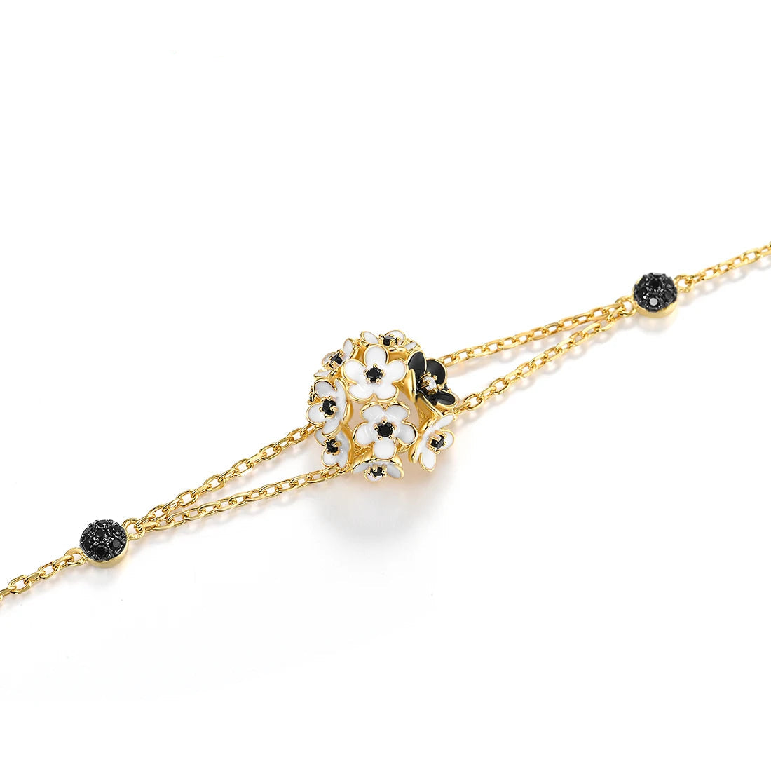 Gold bracelet featuring a cluster of white enamel flowers with black stone centers, from the Fiore Scuro line.