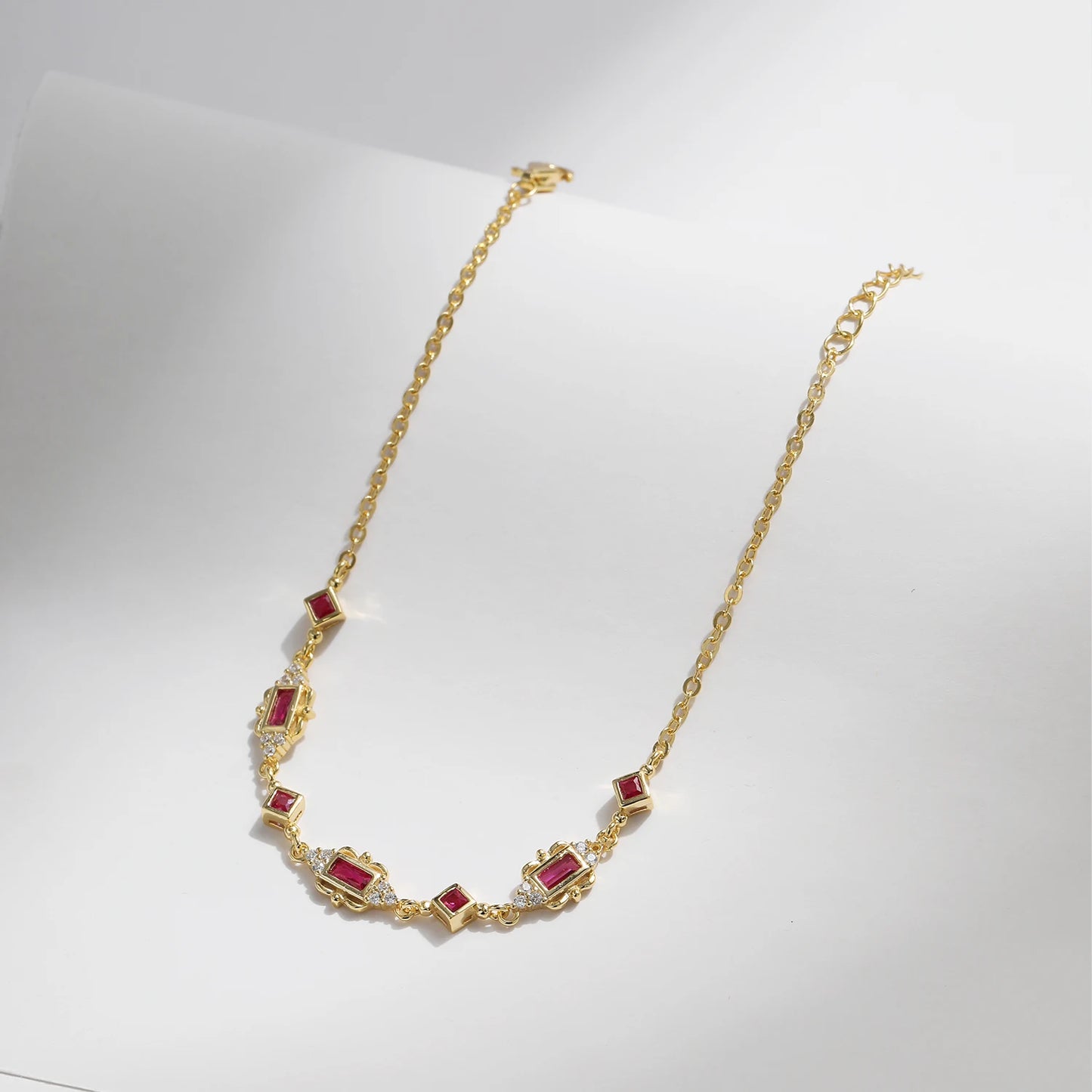 Gold-plated bracelet with ruby-red rectangular and diamond-shaped stones