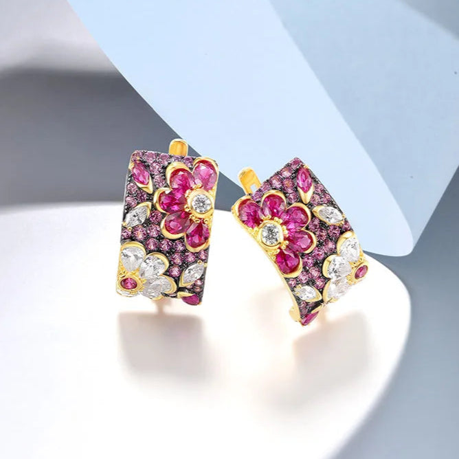 Gold huggie earrings adorned with floral clusters of pink and white stones in marquise and round cuts.
