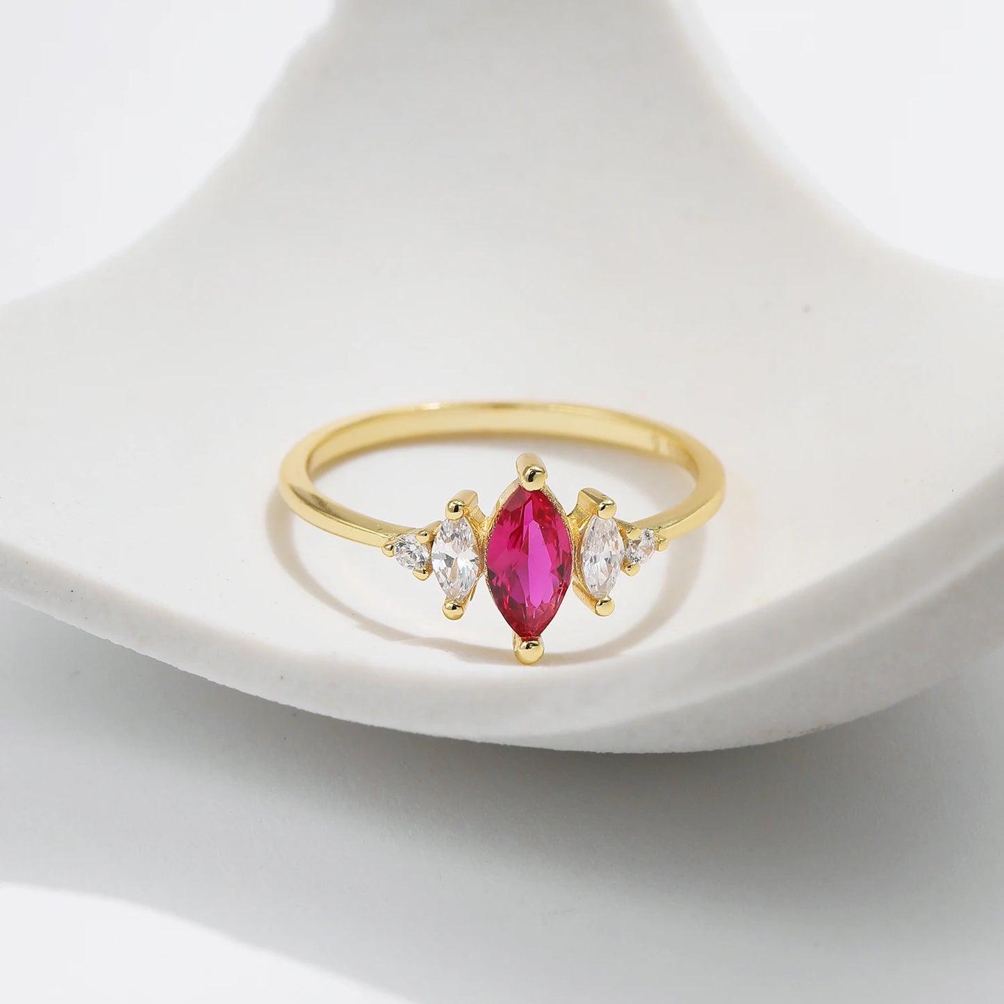 Gold-plated ring with marquise-cut ruby-pink stone and clear side accents
