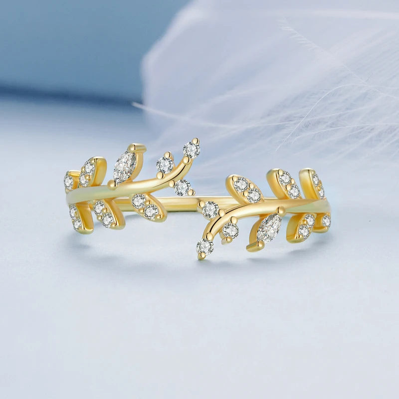 Gold-plated ring featuring two leafy branches set with clear stones, delicately curving toward each other in an open design, from the Bianco Nero collection.