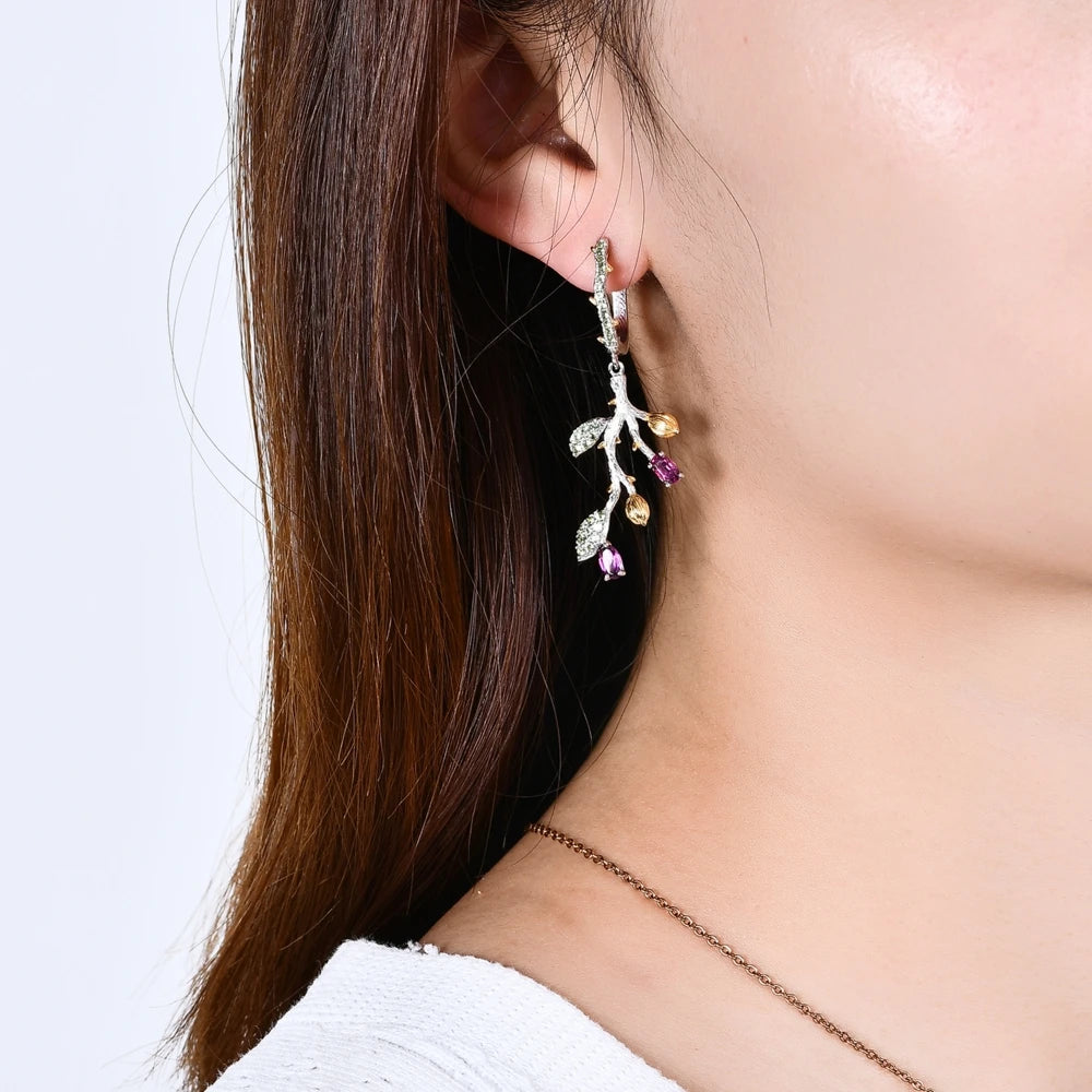 Botanical-inspired earrings with purple, green, and gold accents