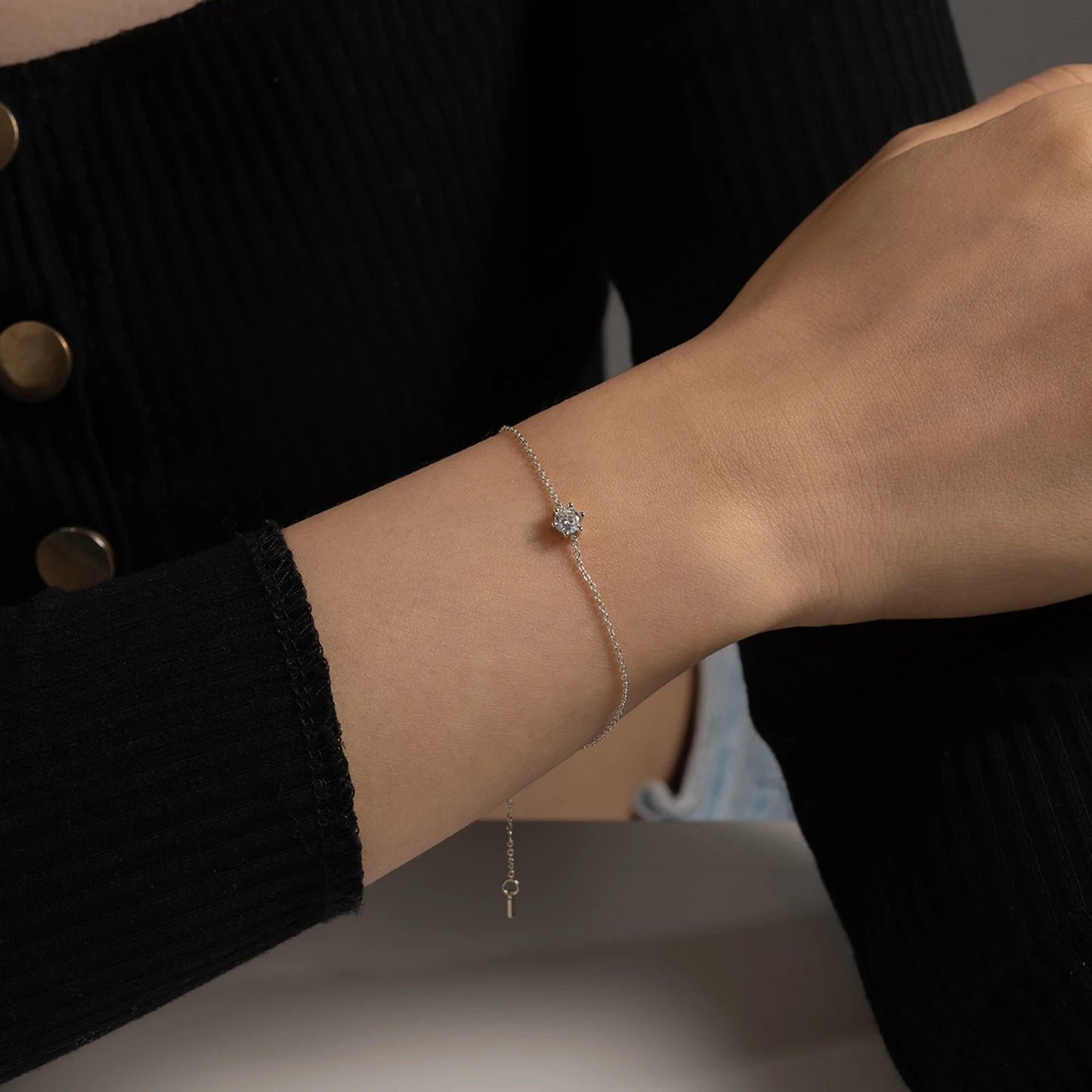 Delicate silver chain bracelet with a single round deep blue gemstone in a minimalist prong setting