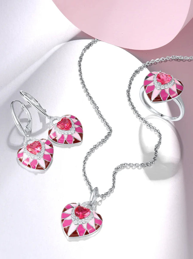 Parete del Cuore jewelry set featuring heart-shaped pink enamel and crystal designs in silver-tone settings, including earrings, pendant, and ring.