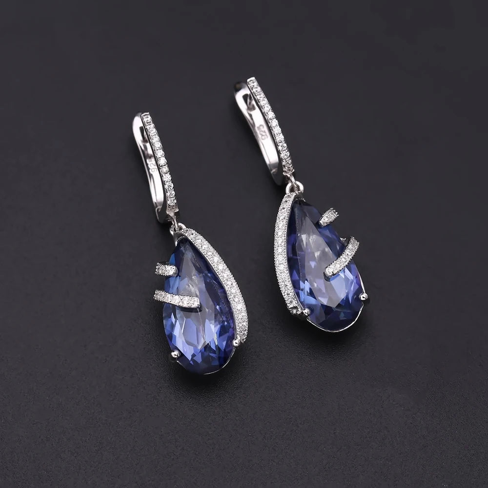 Silver earrings with faceted blue teardrop stones and delicate pavé accents