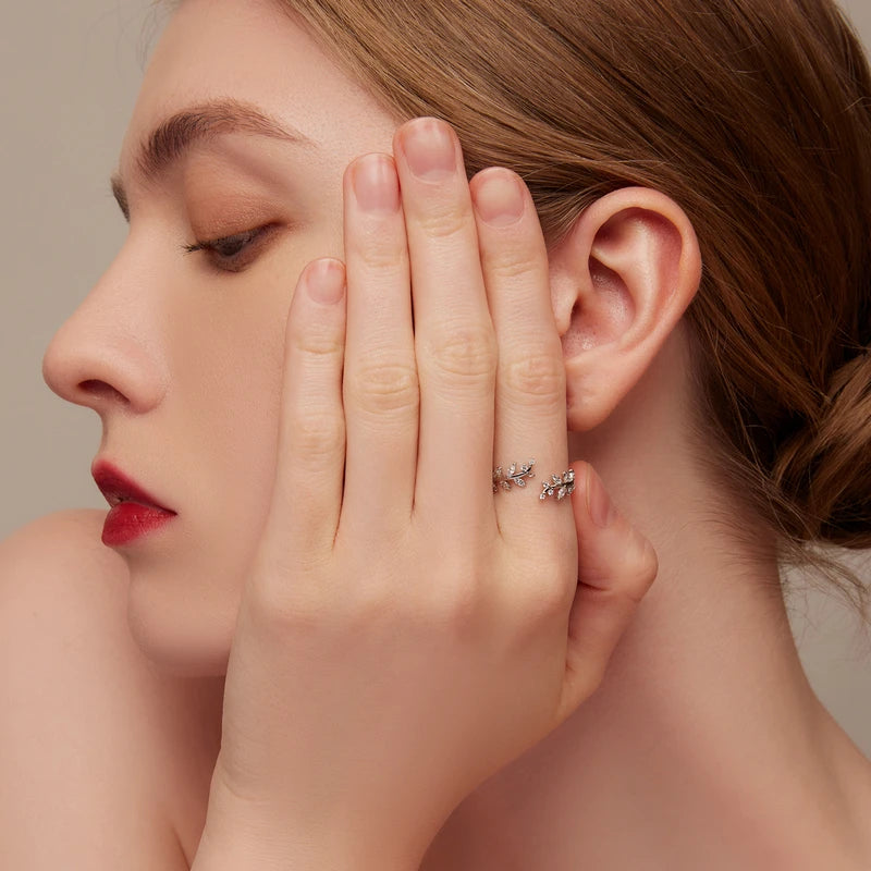 Gold-plated ring featuring two leafy branches set with clear stones, delicately curving toward each other in an open design, from the Bianco Nero collection.