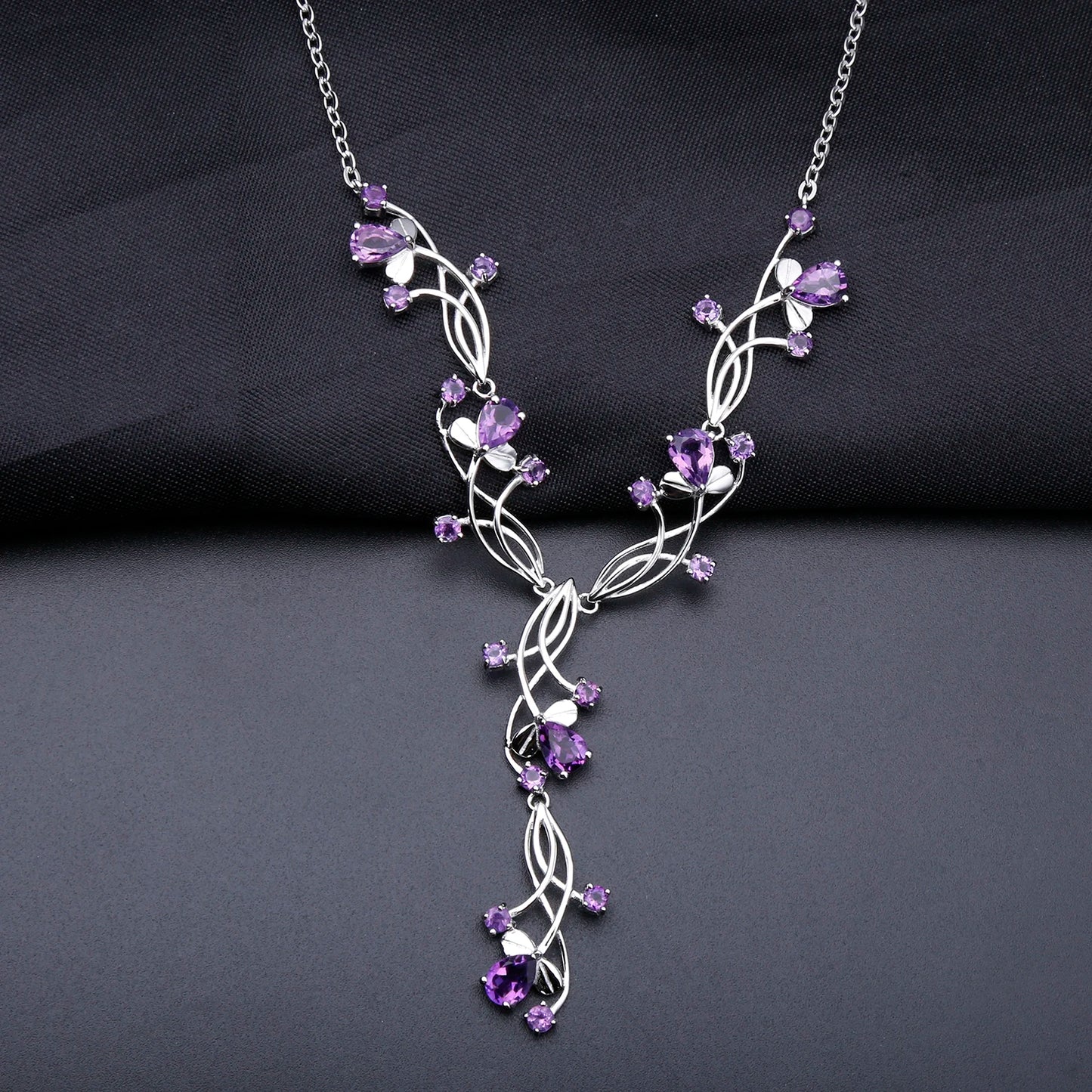 Sterling silver necklace with intertwining strands and purple gemstones arranged in a delicate cascading floral design