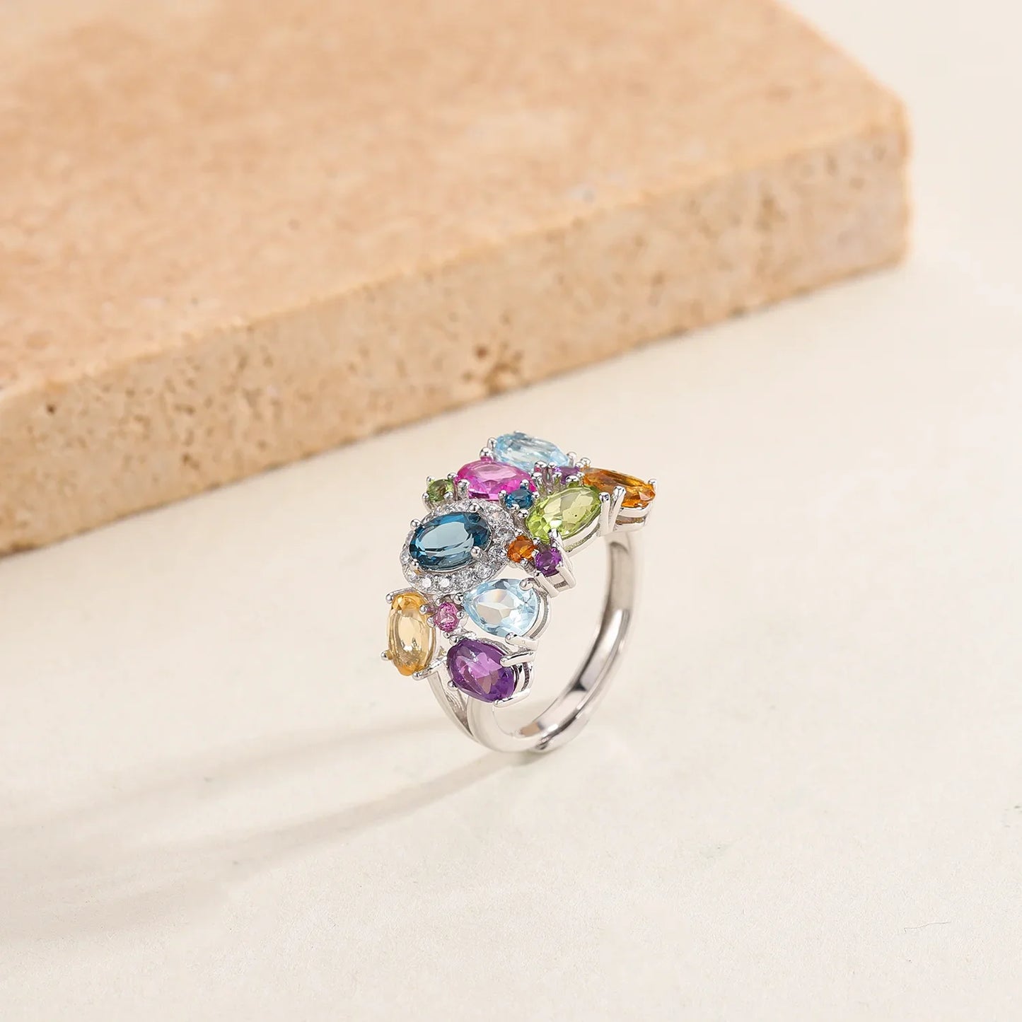 Silver ring with a cluster of multicoloured gemstones in various cuts