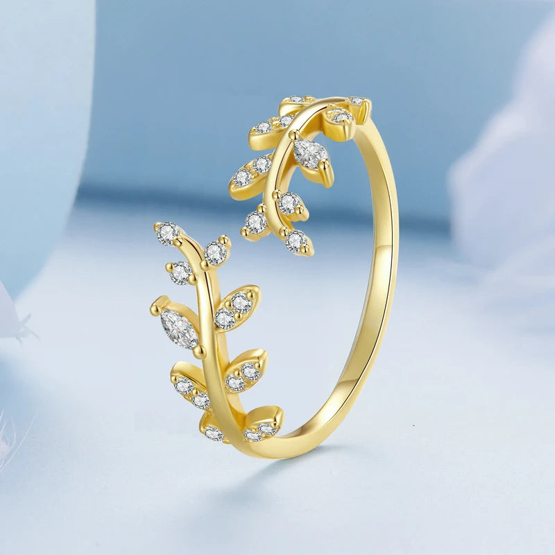 Gold-plated ring featuring two leafy branches set with clear stones, delicately curving toward each other in an open design, from the Bianco Nero collection.