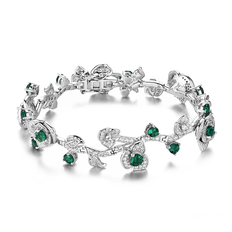 Silver bracelet with green stones and leafy vine design