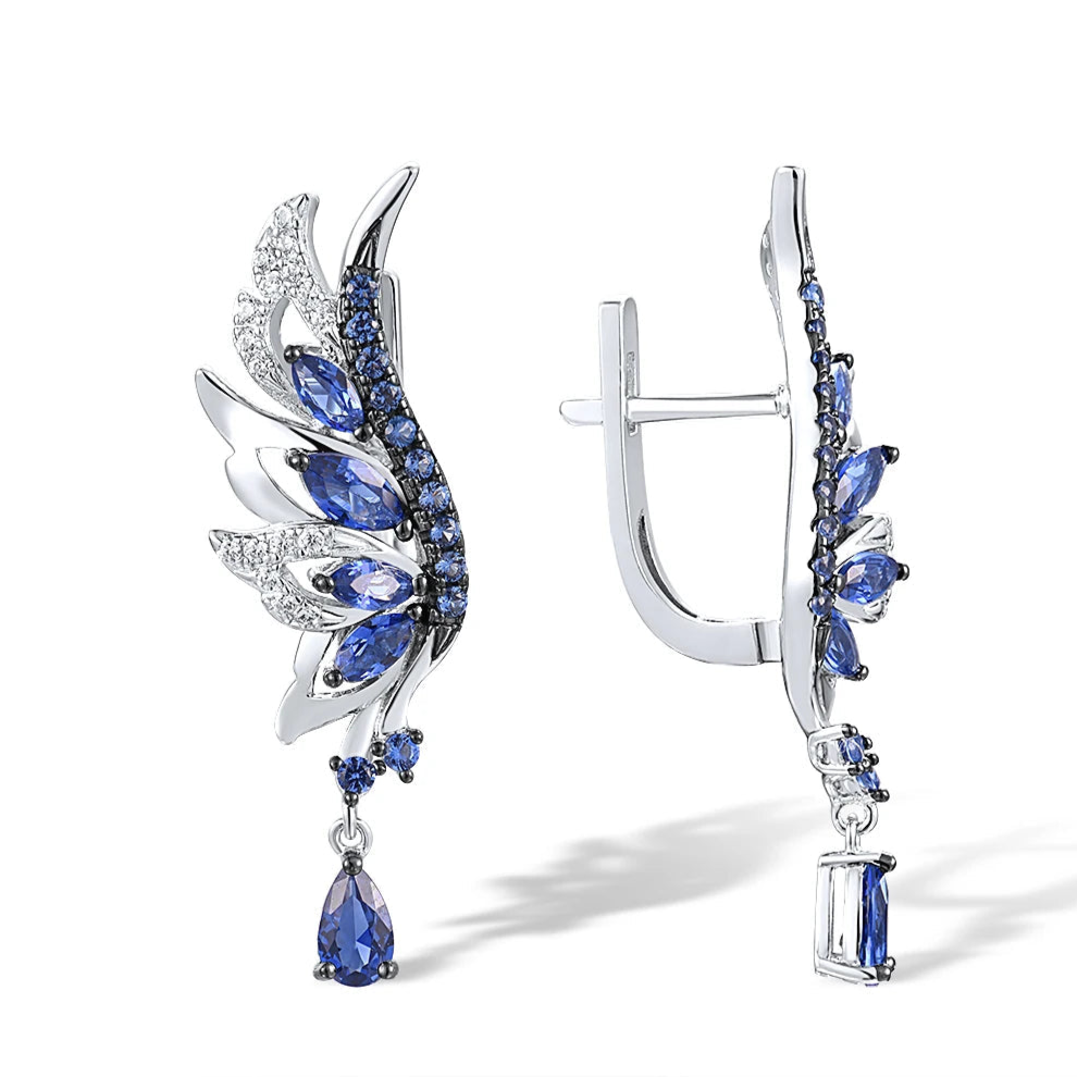 Silver earrings shaped like angel wings, set with layered blue and white stones and teardrop dangles