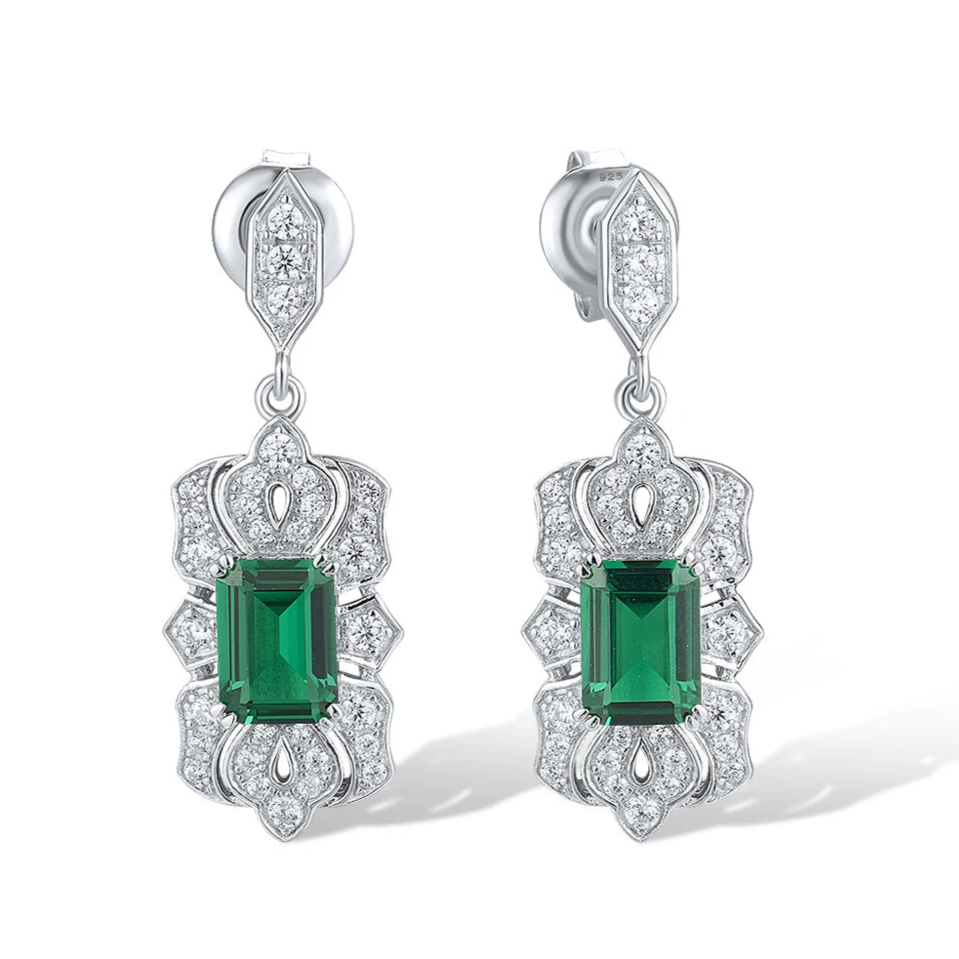 Art Deco-inspired drop earrings with green emerald-cut stones and intricate pavé detailing
