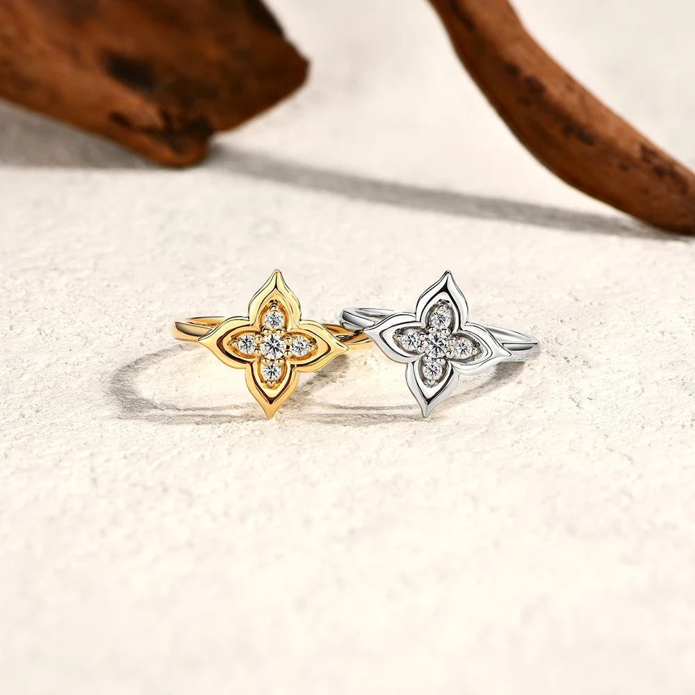 Two star-shaped rings, one gold and one silver, on a light background.
