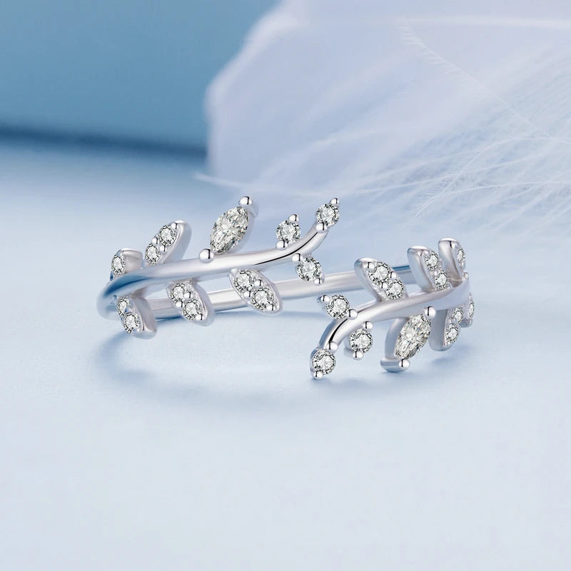 Gold-plated ring featuring two leafy branches set with clear stones, delicately curving toward each other in an open design, from the Bianco Nero collection.