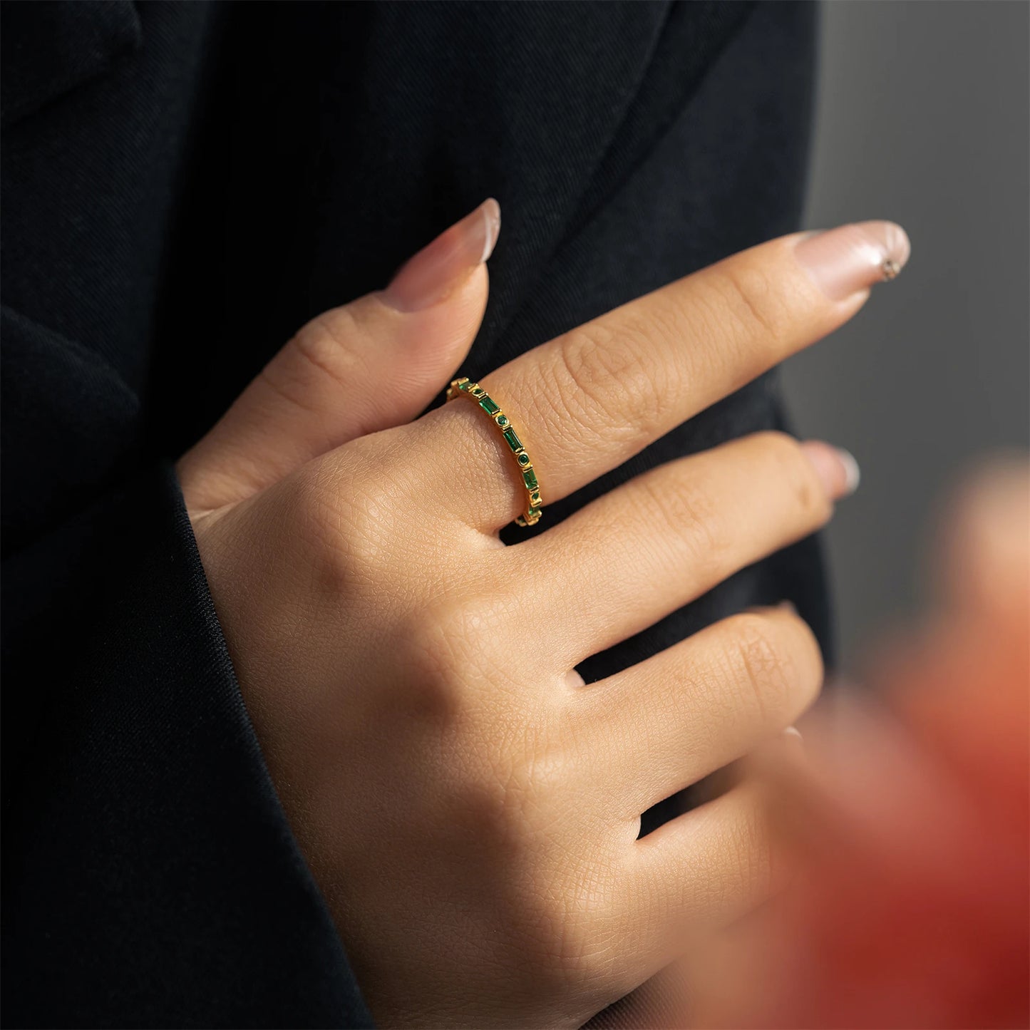 Gold eternity band with alternating round and baguette green stones