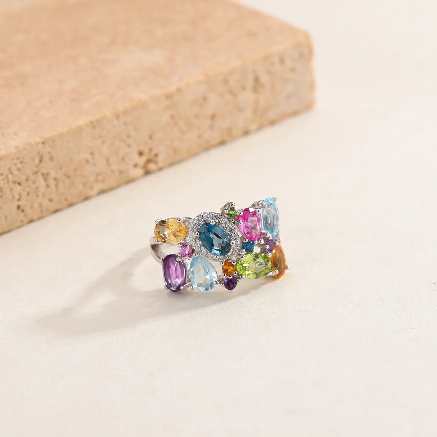 Silver ring with a cluster of multicoloured gemstones in various cuts