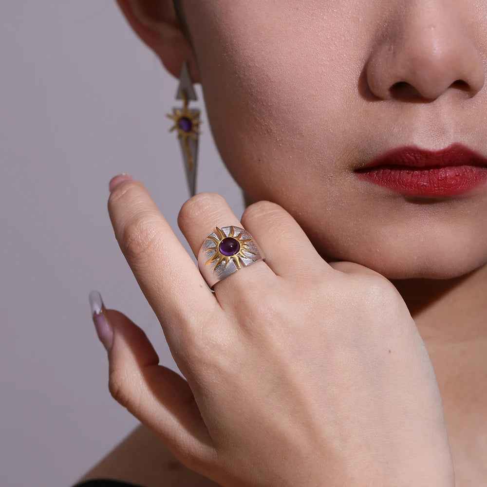 Textured sterling silver ring with golden sun design and central purple cabochon gemstone
