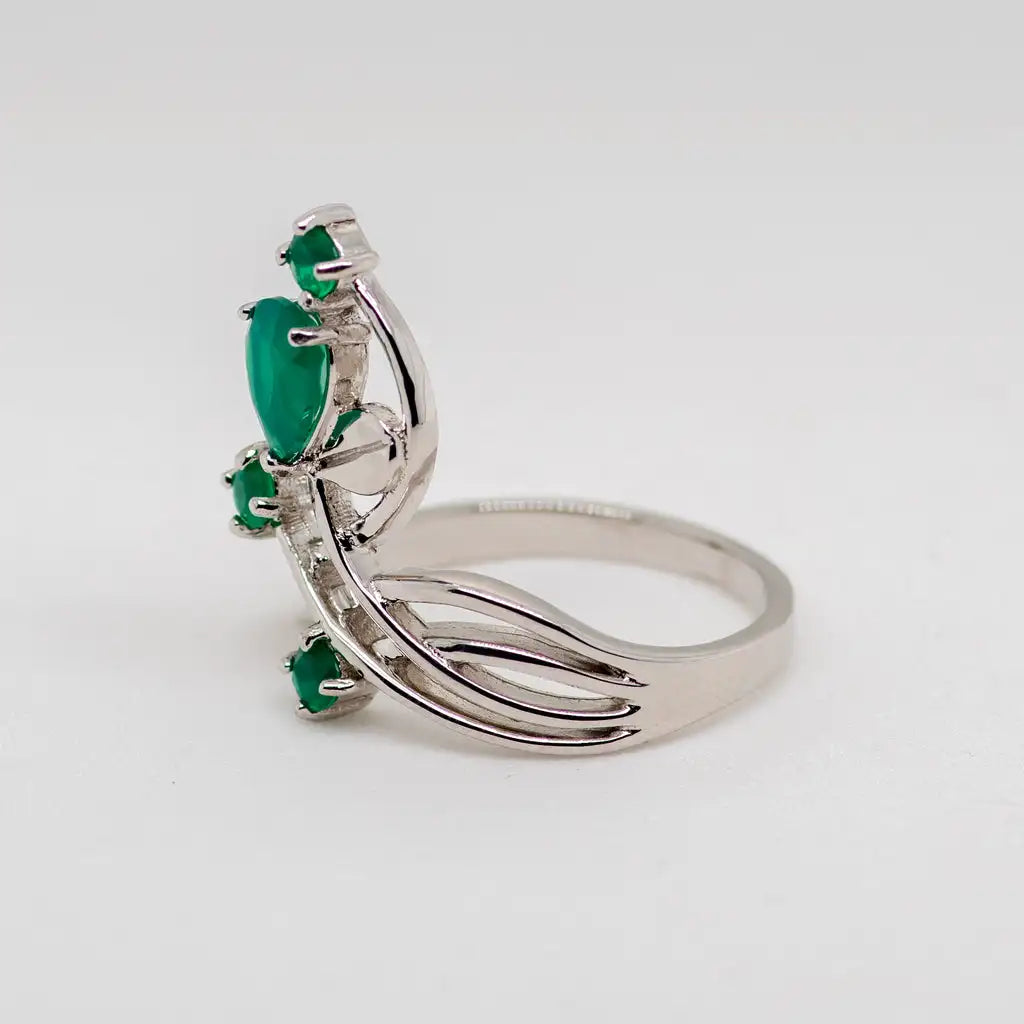 Open silver ring with four green stones arranged like petals on curved stems