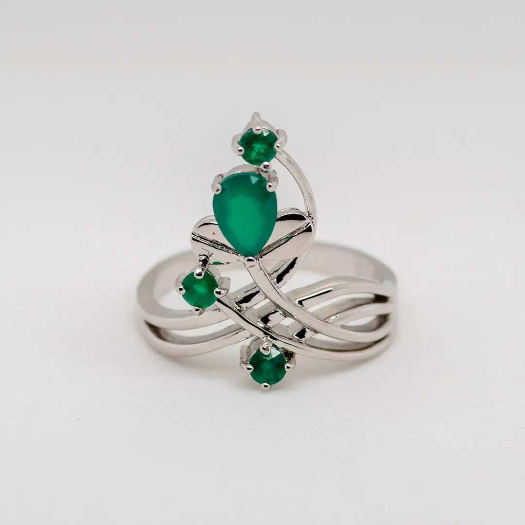 Open silver ring with four green stones arranged like petals on curved stems