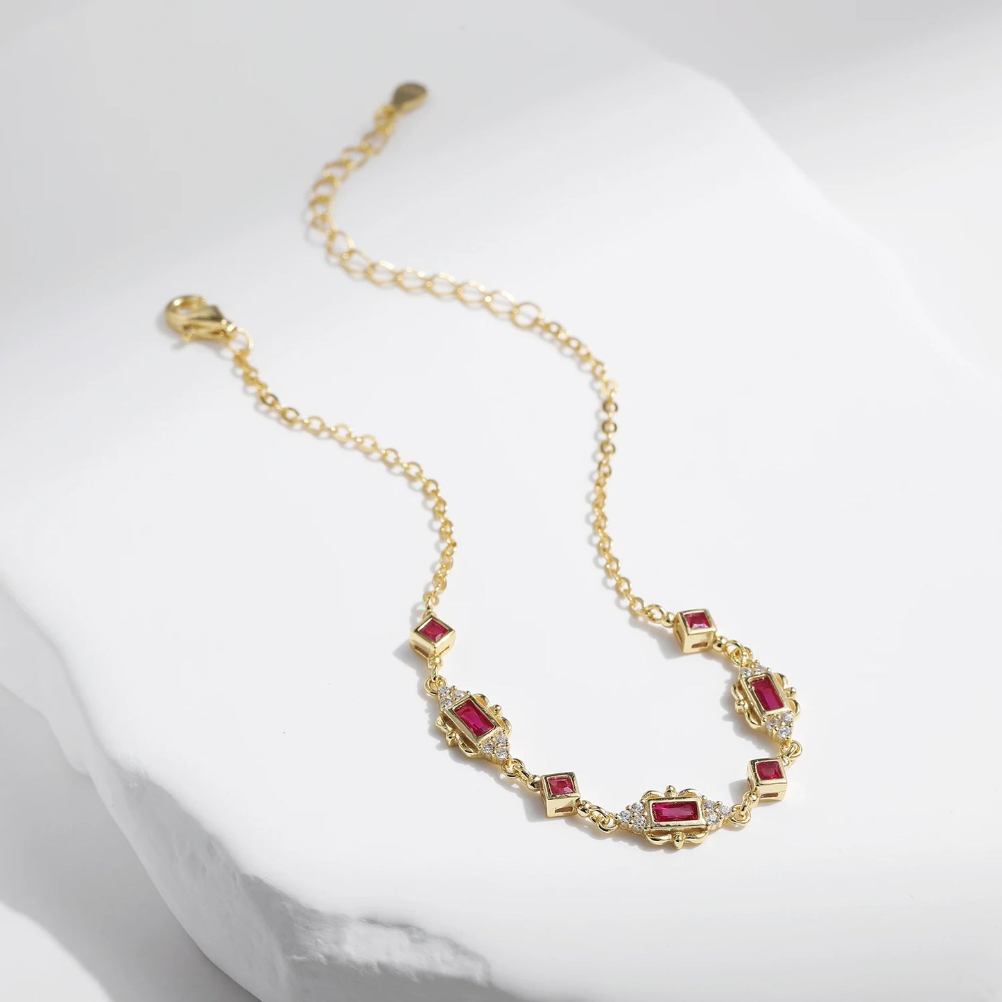 Gold-plated bracelet with ruby-red rectangular and diamond-shaped stones