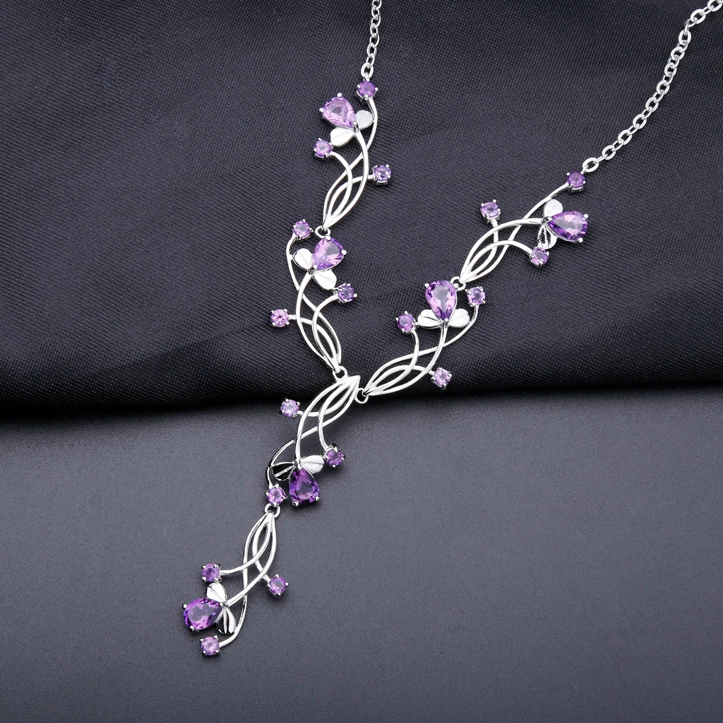 Sterling silver necklace with intertwining strands and purple gemstones arranged in a delicate cascading floral design