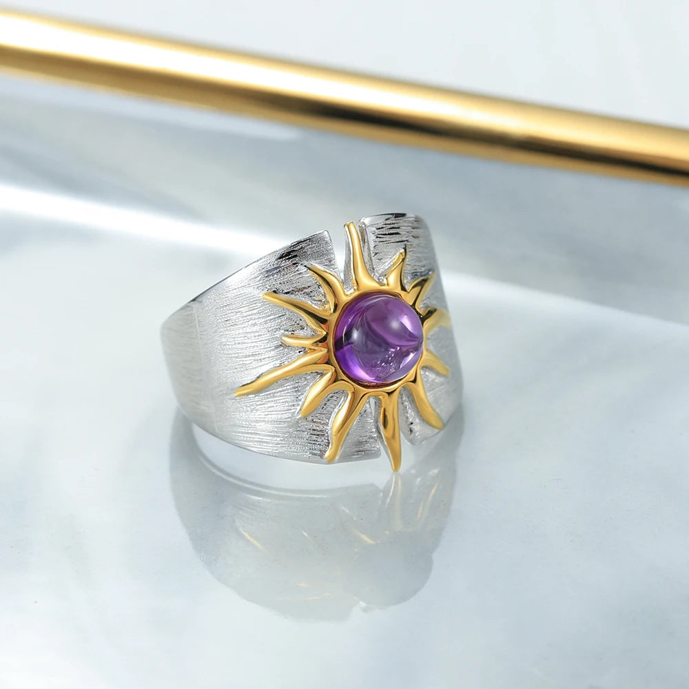 Textured sterling silver ring with golden sun design and central purple cabochon gemstone