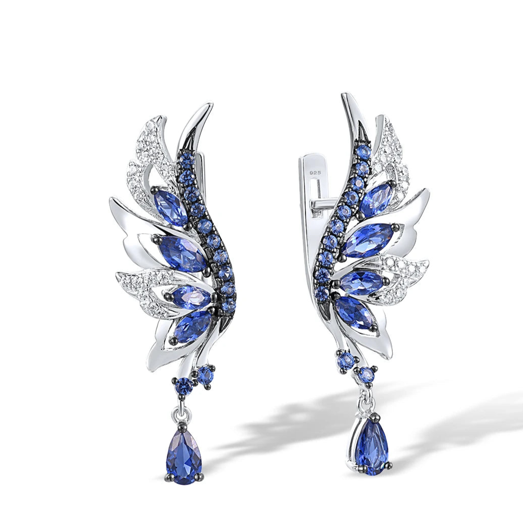Silver earrings shaped like angel wings, set with layered blue and white stones and teardrop dangles