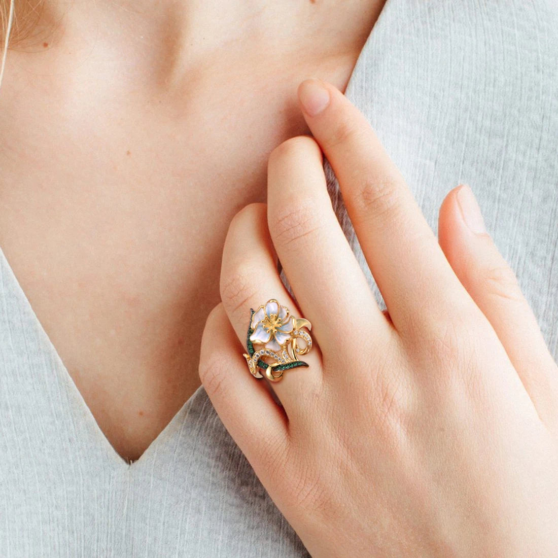 Gold ring with pastel enamel flower, green and clear stones on entwined vine-like details, from the Nastro Verde line.