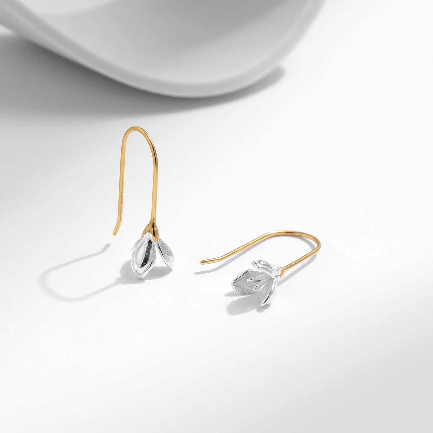 Gold hook earrings with delicate silver flower bud drops.