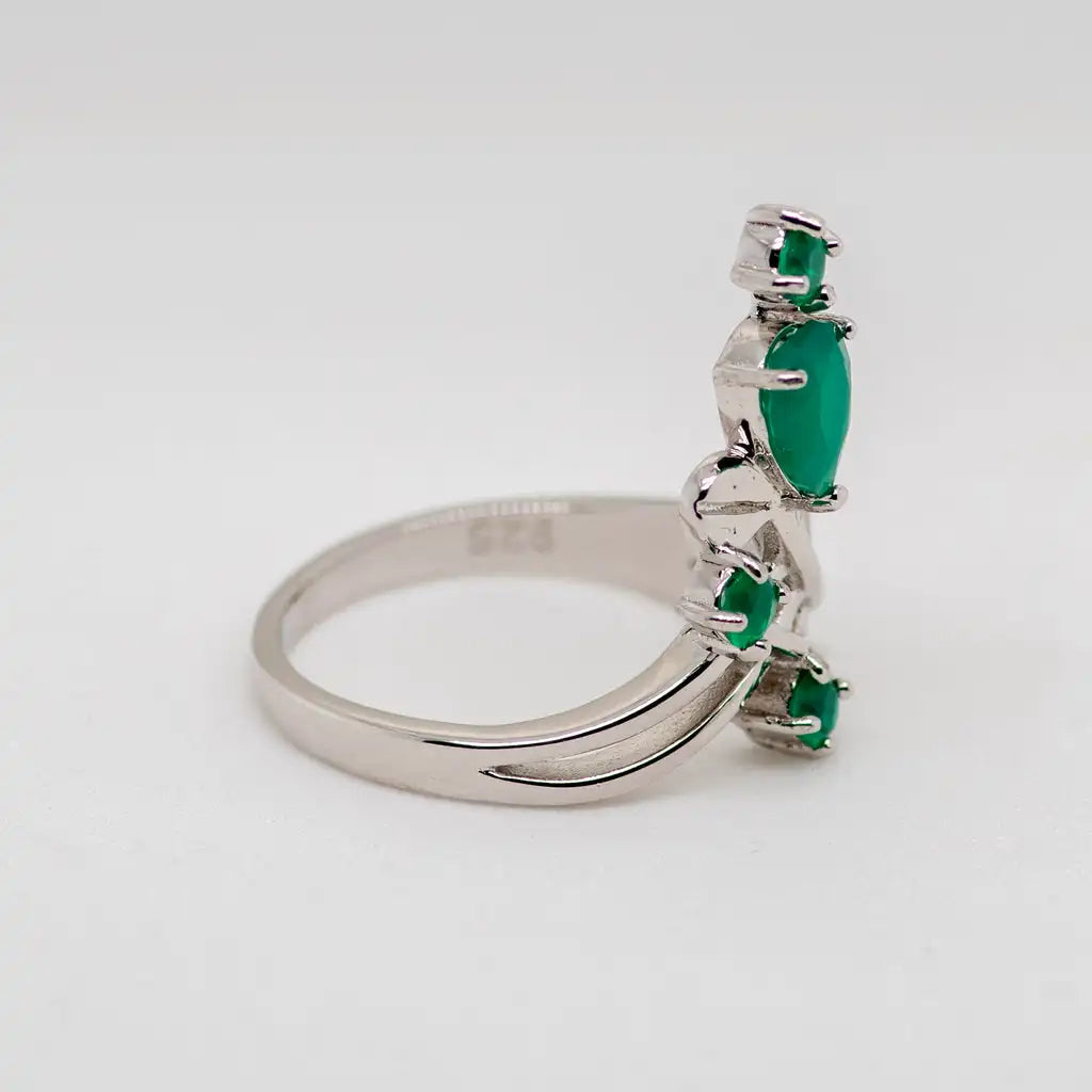 Open silver ring with four green stones arranged like petals on curved stems