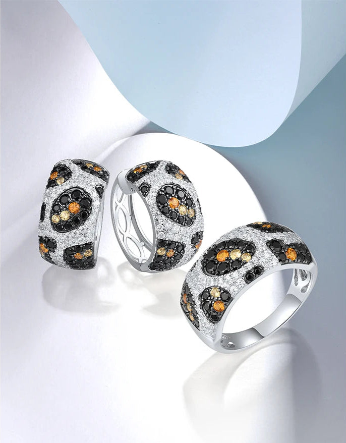 Matching jewelry set with leopard-inspired design in silver and gemstone accents, including ring and earrings, titled Pardus Lux.