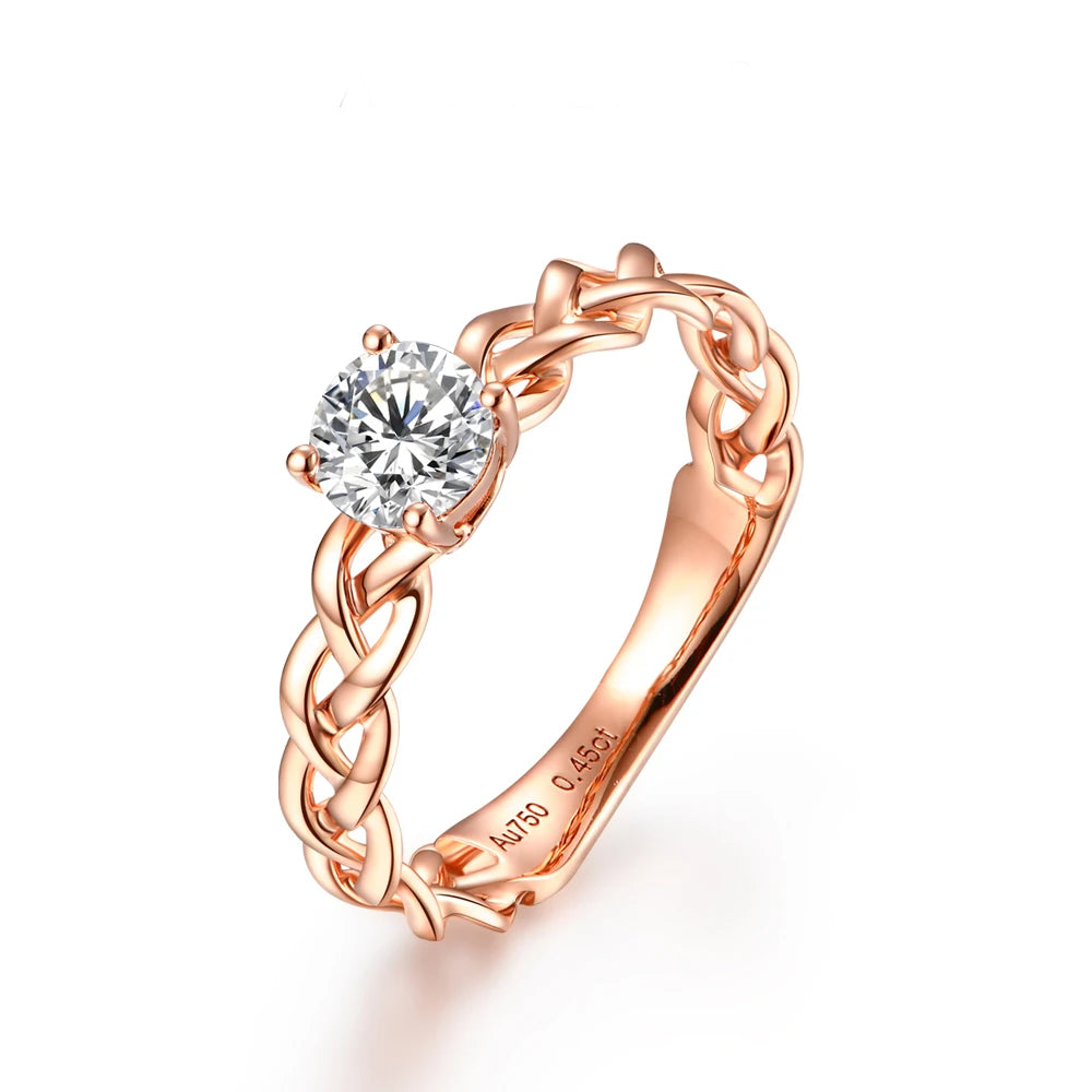 Gold ring with a braided band design and a round-cut clear central stone in a four-prong setting.