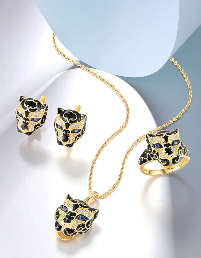 Occhi di Blu jewelry set featuring gold-tone leopard heads with sapphire blue eyes and black enamel detailing from the Bianco Nero collection.