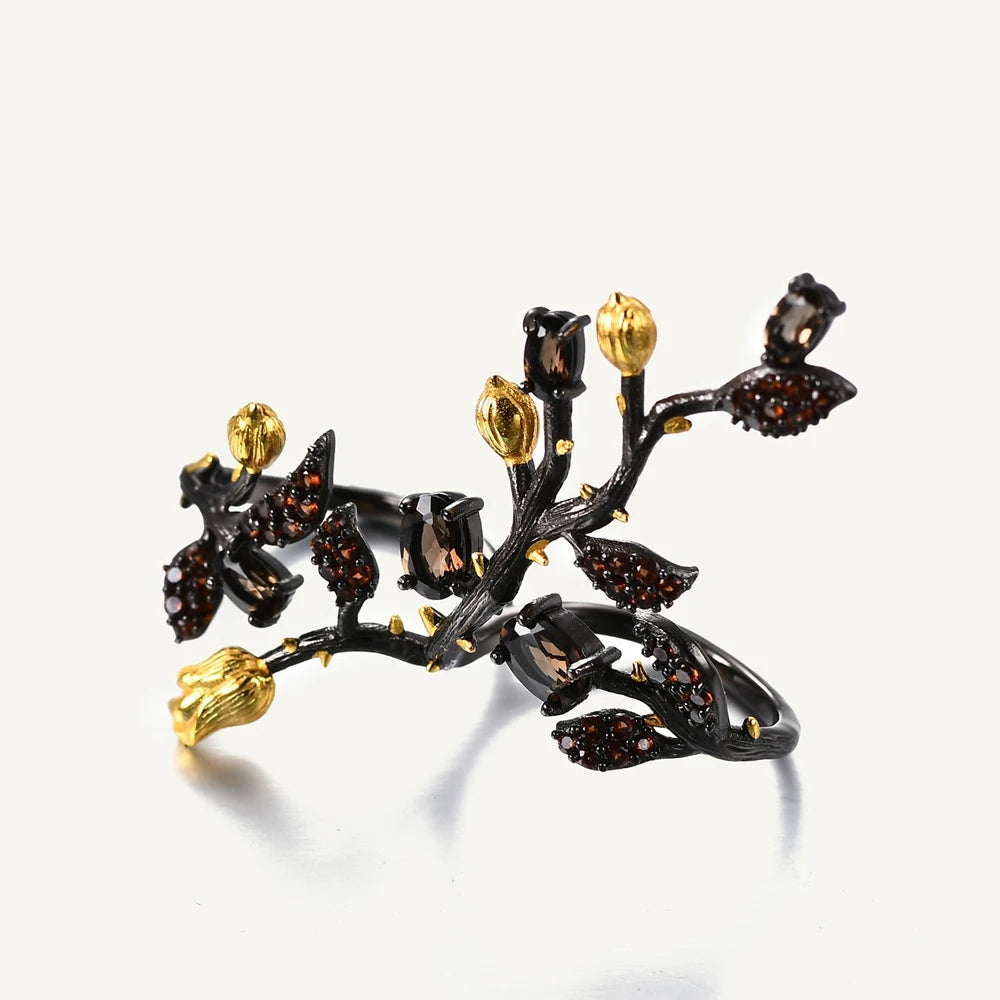 Double-finger black ring shaped like a flowering branch with purple, green, and gold detailing