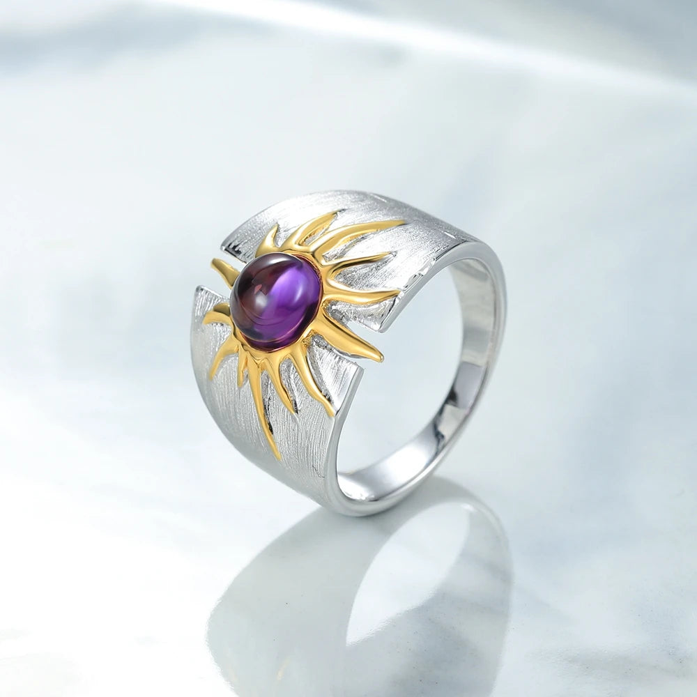 Textured sterling silver ring with golden sun design and central purple cabochon gemstone