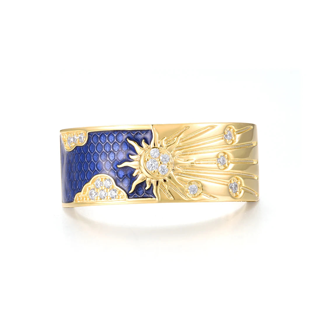 Gold-plated silver ring with a radiant sunburst design, sparkling stones, and deep blue enamel detailing