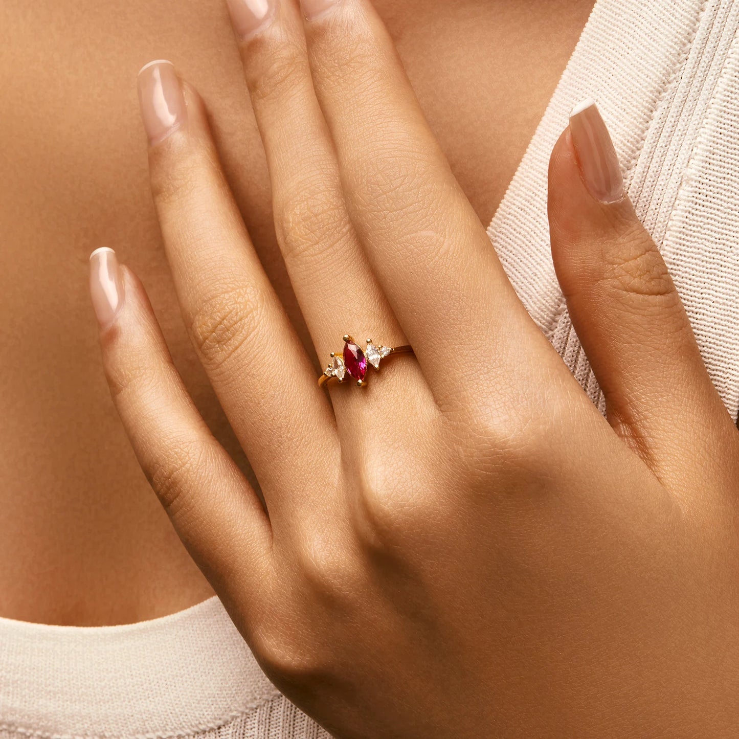 Gold-plated ring with marquise-cut ruby-pink stone and clear side accents