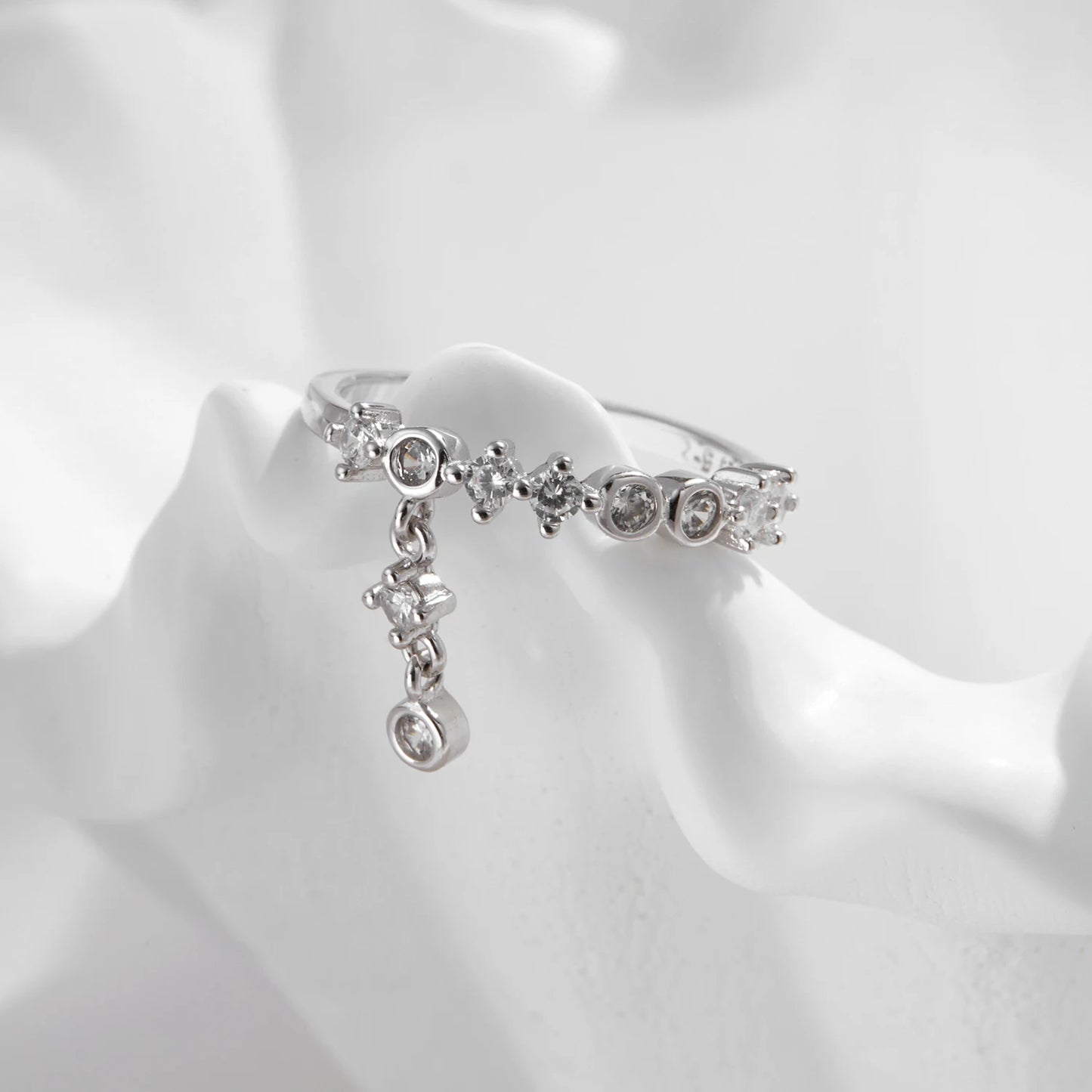 Silver ring with a line of round-cut stones and three delicate cubic zirconia drops