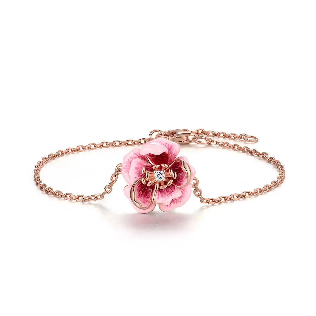 Anemone bracelet with a delicate chain and a central pink flower charm detailed with enamel and a sparkling center stone.