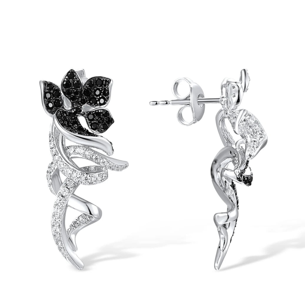 Asymmetric silver earrings with black and white floral designs and pavé details