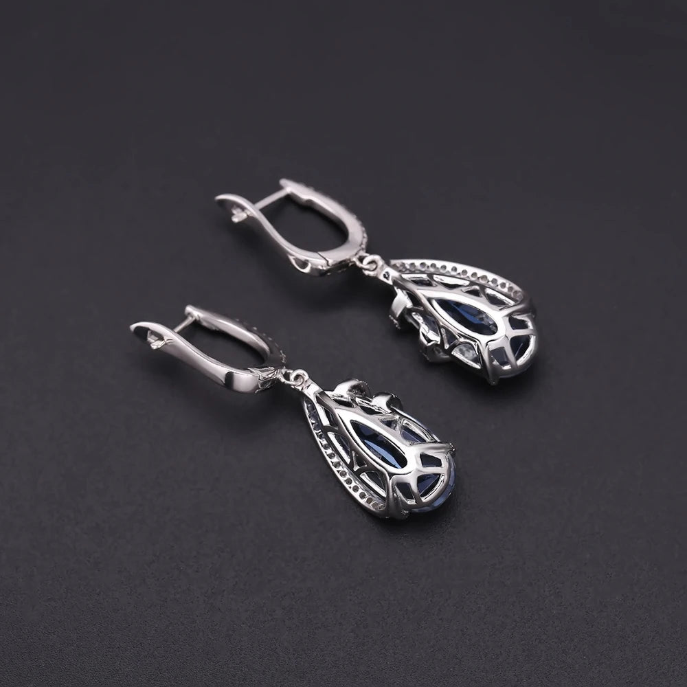 Silver earrings with faceted blue teardrop stones and delicate pavé accents